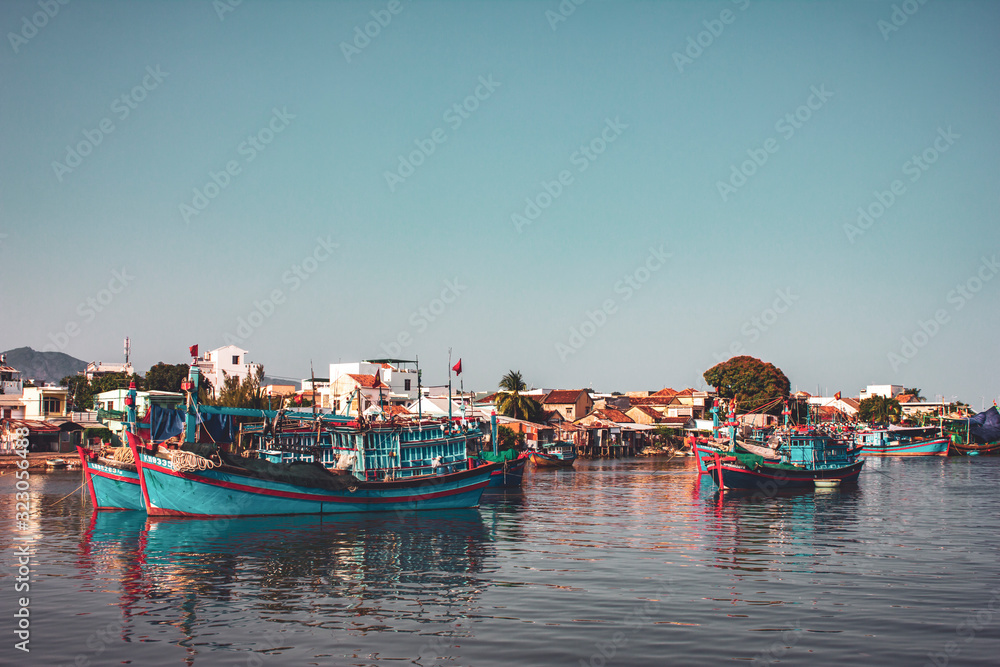 Fishing boats against the backdrop of the city during sunset