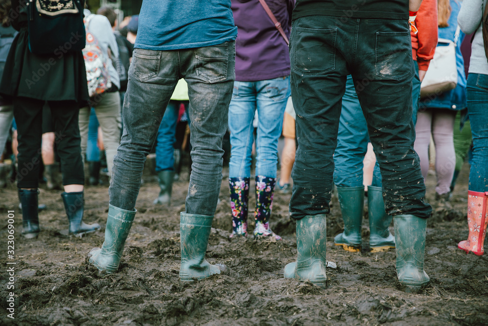 Closeup of muddy wellingtons. People attending on a rainy day at a music festival. Closeup of muddy wellingtons. People attending on a rainy day at a music festival.