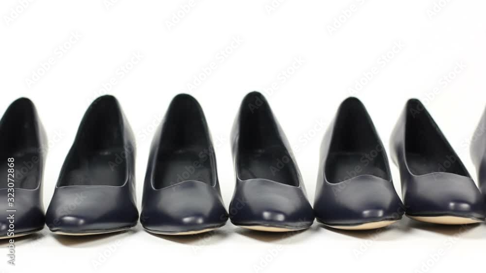 Stand out from the crowd - A line of black shoes and then a pair of Red high heel shoes -Tracking shot on White Background. Stock Video Clip Footage Stand out from the crowd - A line of black shoes and then a pair of Red high heel shoes -Tracking shot on White Background. Stock Video Clip Footage