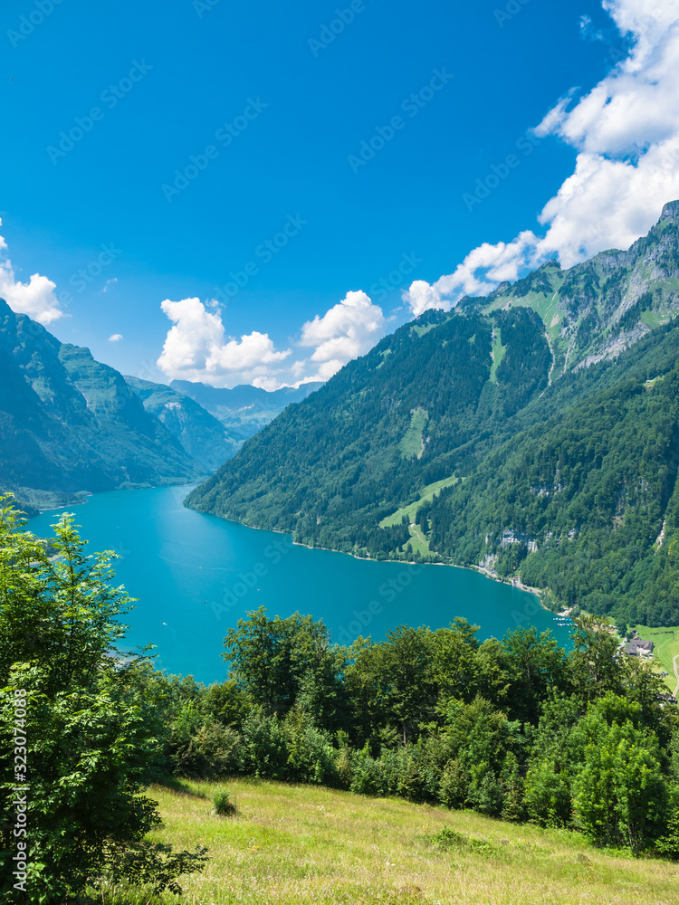 Beautiful aerial view of Kloental lake (Kloenthalsee) and valley, Swiss Alps, on a sunny summer day with blue sky cloud, Canton of Glarus, Switzerland