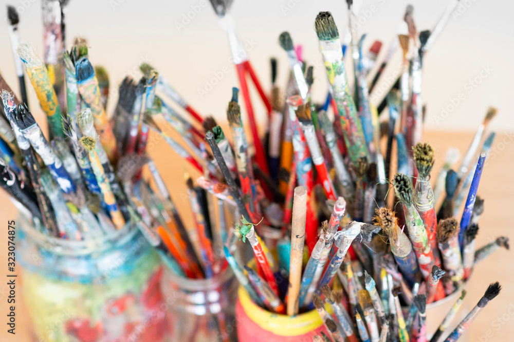 Fototapeta premium A lot dirty artist paint brushes in a bucket