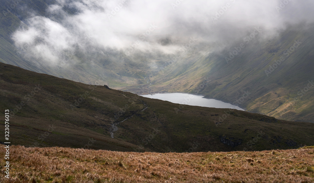 View of Hayeswater Reservoir below cloud and the summits of High Street and Gray Crag in the Lake District UK.