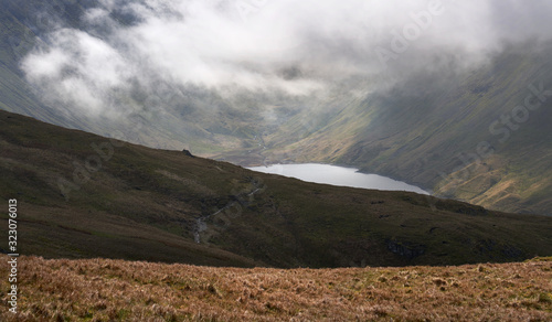 View of Hayeswater Reservoir below cloud and the summits of High Street and Gray Crag in the Lake District UK.