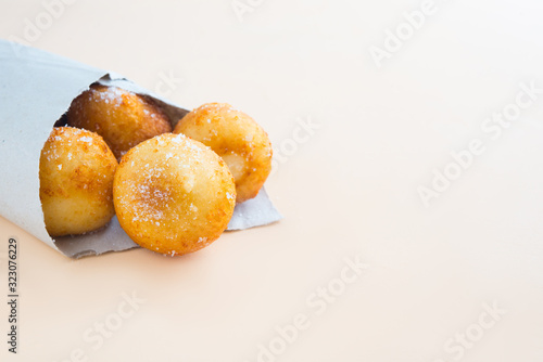 French doughnuts Beignet covered with sugar powder on a brown background
