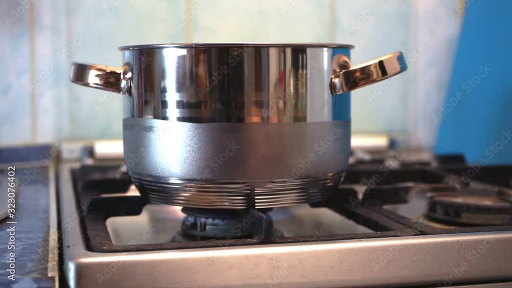 Metal cooking pot standing on gas stove with flame.Kitchenware cooking. Metal cooking pot standing on gas stove with flame.Kitchenware cooking.