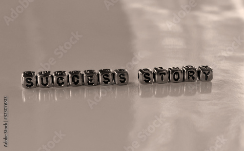 Success story -  word from metal blocks - concept sepia tone photo on shine background