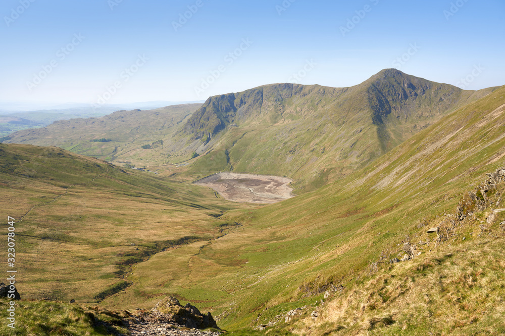 The two mountain summits of Yoke and Ill Bell a above Kentmere common and reservoir on a sunny morning in the Lake District UK.