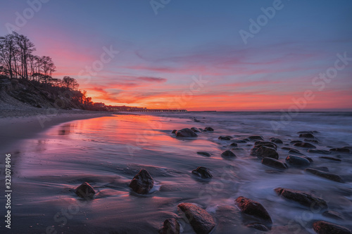 rocky beach of the sea at magenta sunset