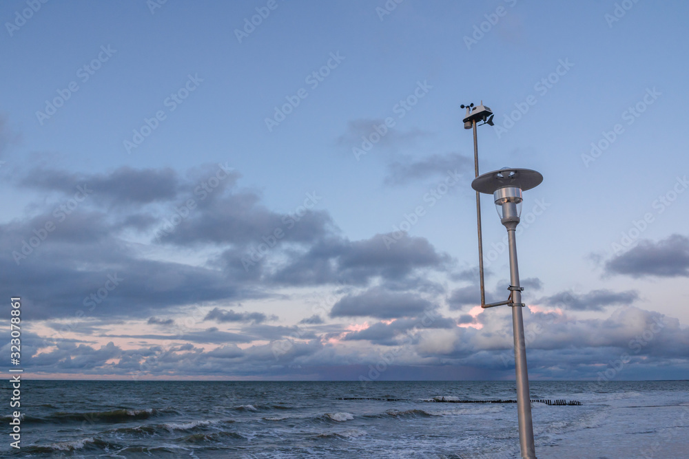 small weather station on a pillar above a stormy sea