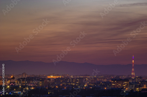Red sunset sky over the city and mountains silhouette