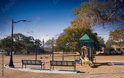 Two empty benches at a playground with a lighthouse in the background