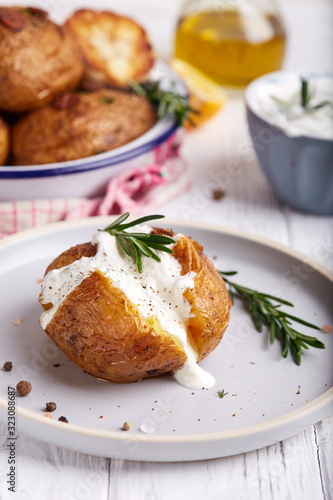 Whole potato roasted with rosemary and spices, served with sour cream sauce. Vegetarian dish. 