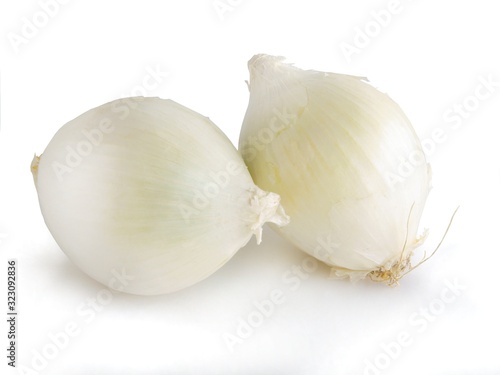 white and gold raw onions with green leaves for salad