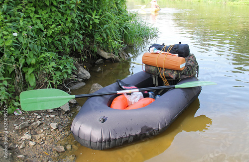 small packraft, a type of inflatable boat, loaded with packed stuff photo