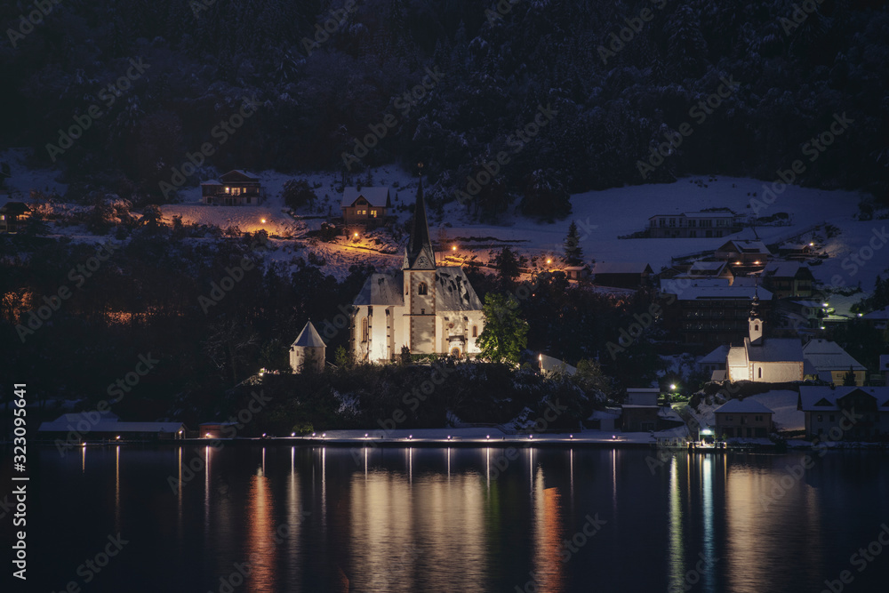 Small town houses alongside the lake in Worthersee, Austria at dusk
