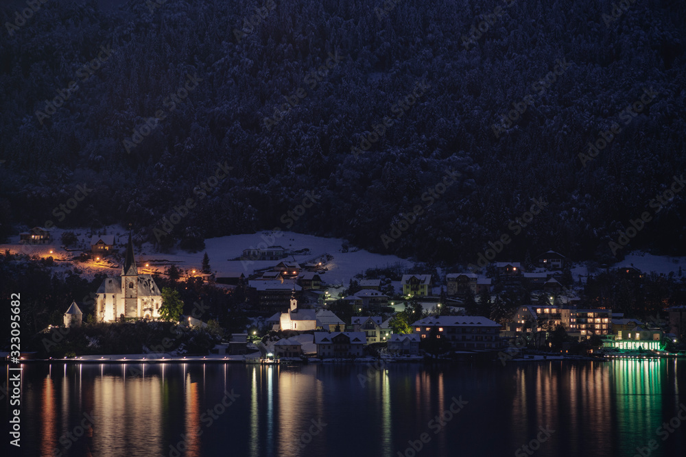 Small town houses alongside the lake in Worthersee, Austria at dusk