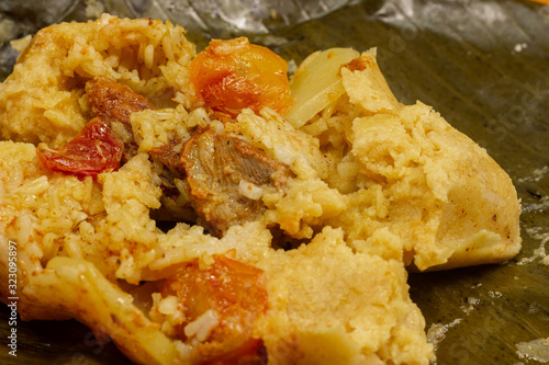 Nacatamal typical Nicaraguan food, corn, meat, butter, potatoes, onion, wrapped banana leaf photo