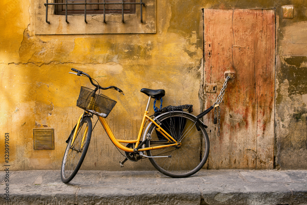 Yellow bicycle chained to a door handle