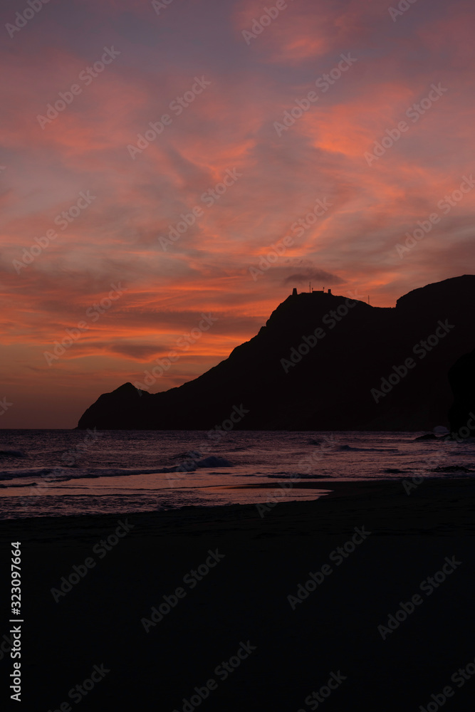 Abenddämmerung spanische Küste, rote Wolken, Bucht mit Felsen