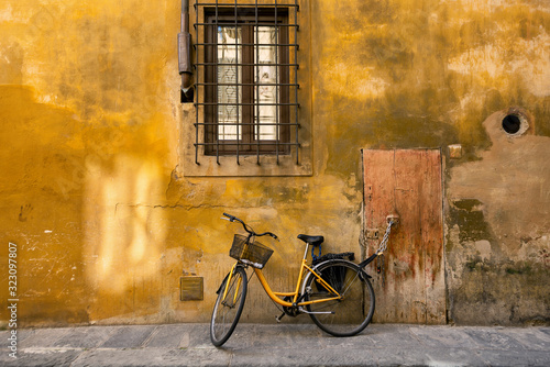 Yellow bicycle chained to a door handle
