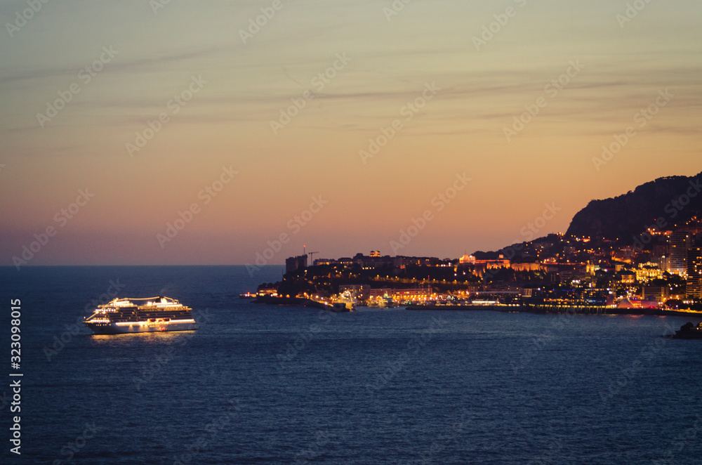 Cruise ship leaving Monaco Monte Carlo bay at dusk