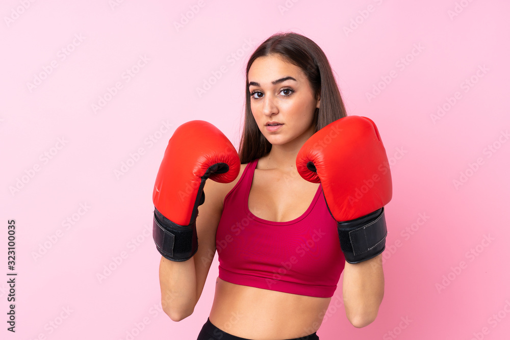 Young sport girl over isolated pink background with boxing gloves