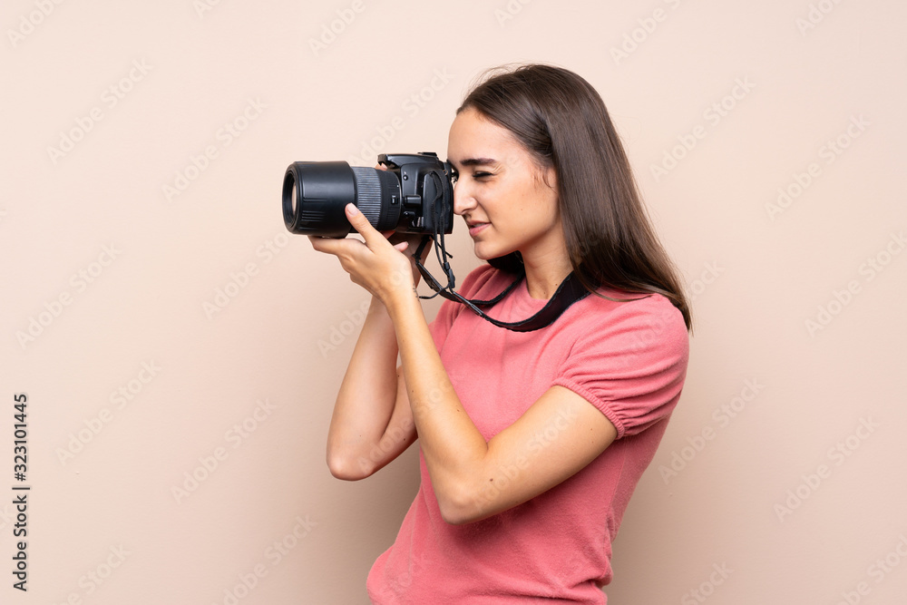 Young woman over isolated background with a professional camera Young woman over isolated background with a professional camera