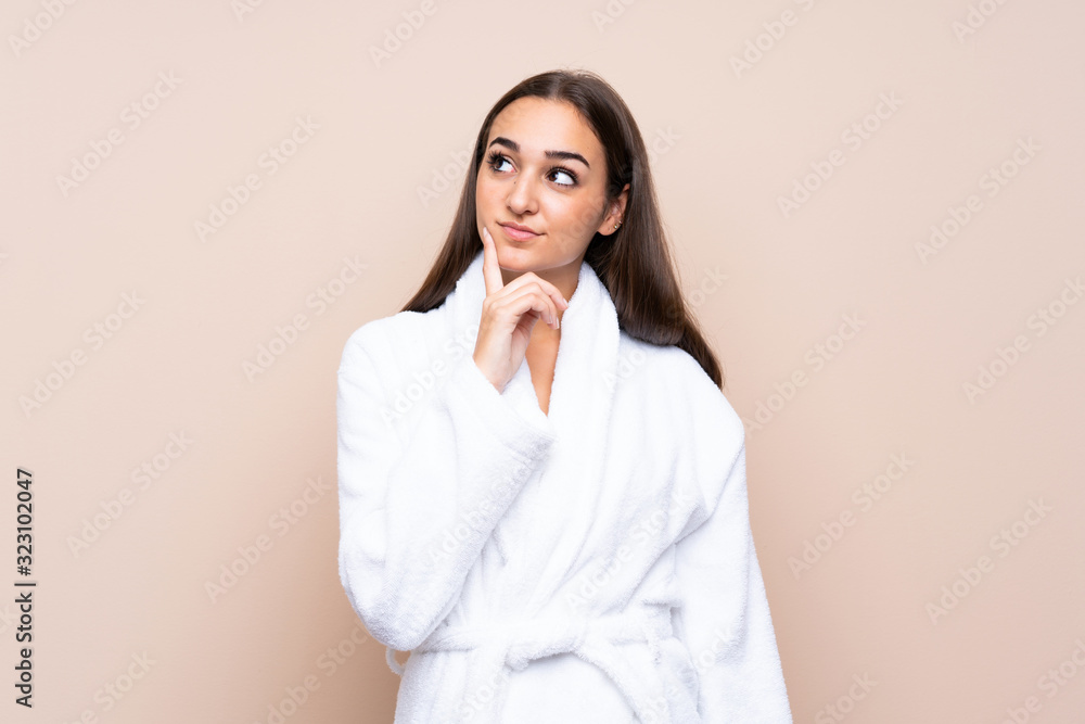 Young girl in a bathrobe over isolated background thinking an idea Young girl in a bathrobe over isolated background thinking an idea