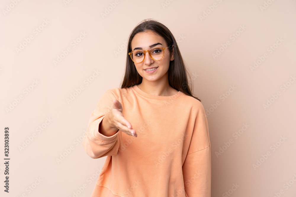 Young girl over isolated background handshaking after good deal Young girl over isolated background handshaking after good deal