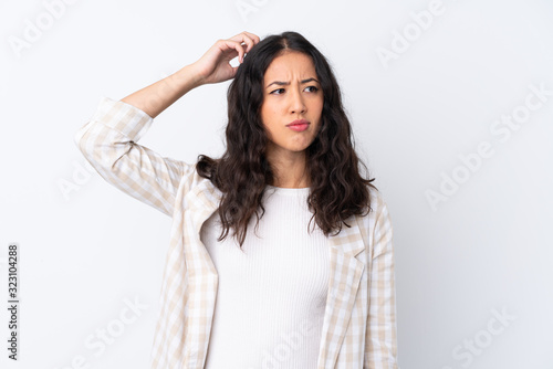 Foto Mixed race woman over isolated white background having doubts while scratching h