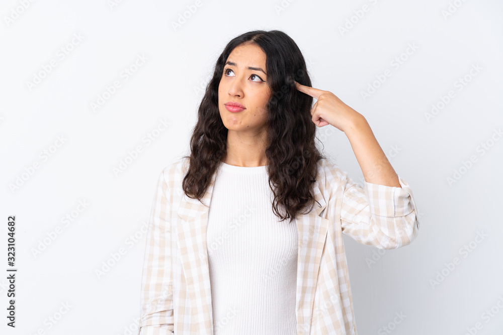 Mixed race woman over isolated white background making the gesture of madness putting finger on the head Mixed race woman over isolated white background making the gesture of madness putting finger on the head