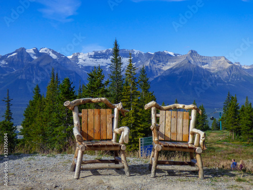 Two wood chairs on top of a ski mountain in summer at Banff National Park