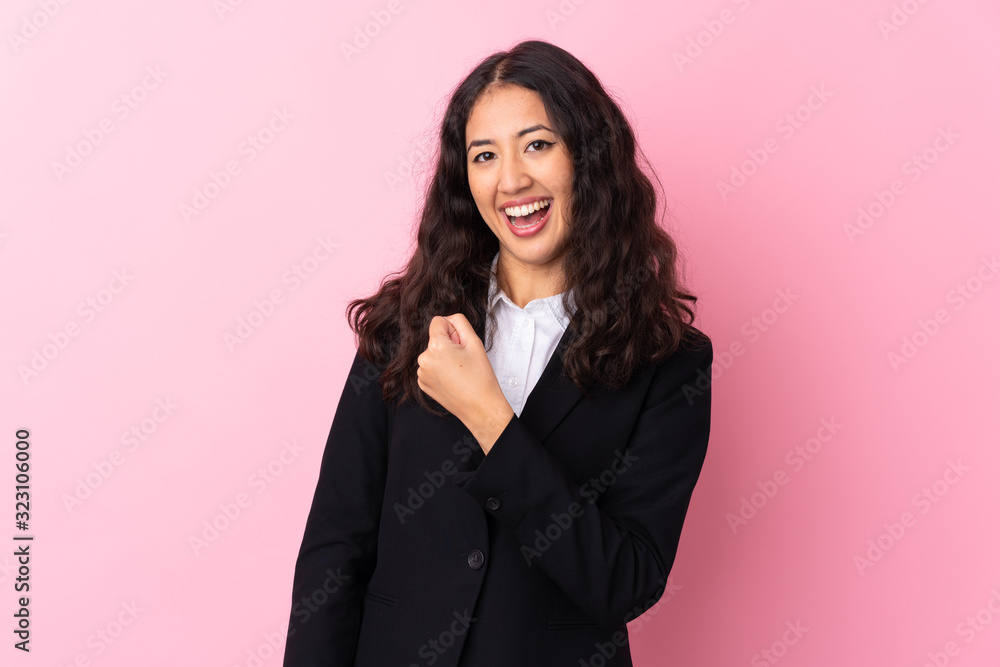 Mixed race business woman over isolated pink background celebrating a victory Mixed race business woman over isolated pink background celebrating a victory