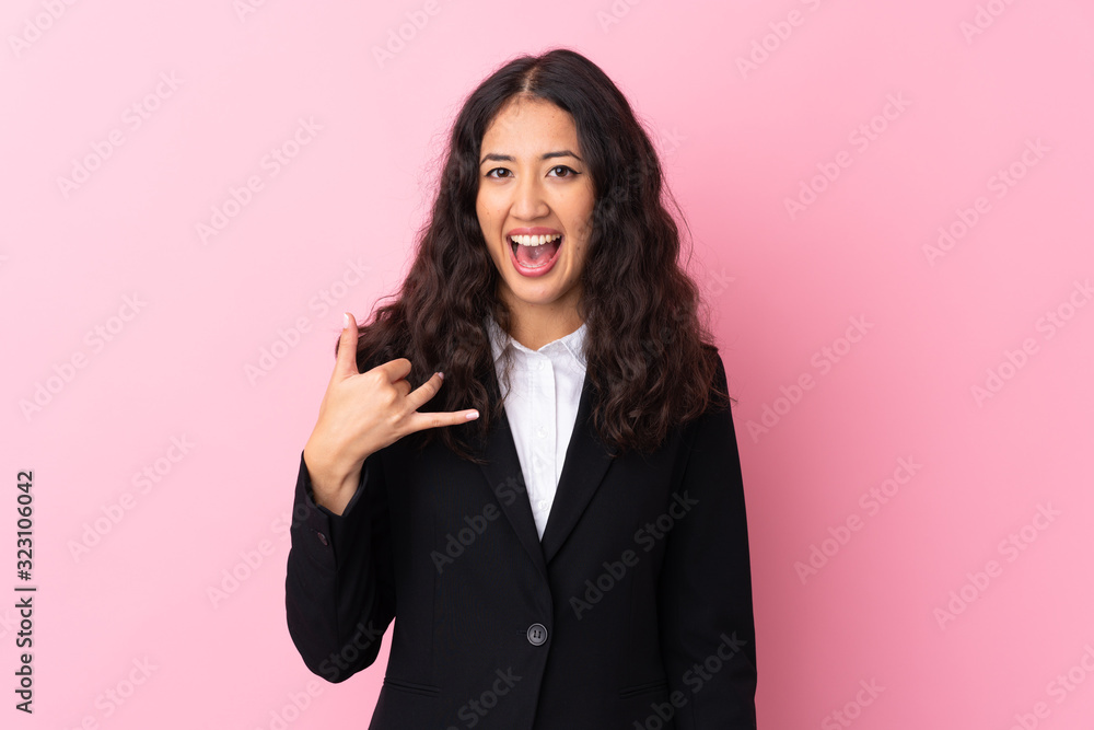 Mixed race business woman over isolated pink background making phone gesture Mixed race business woman over isolated pink background making phone gesture