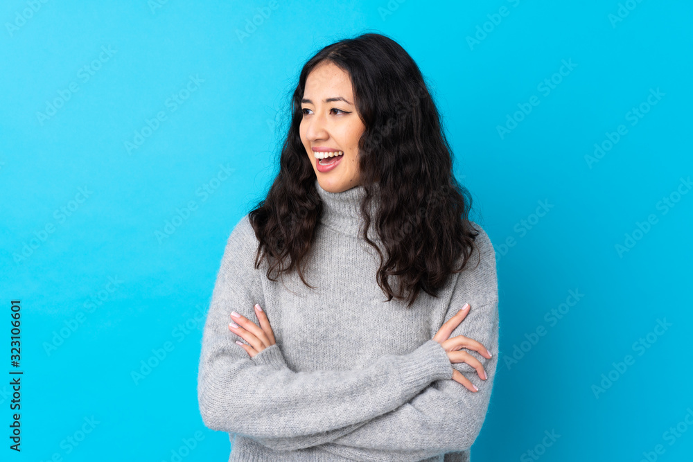 Spanish Chinese woman over isolated blue background happy and smiling Spanish Chinese woman over isolated blue background happy and smiling