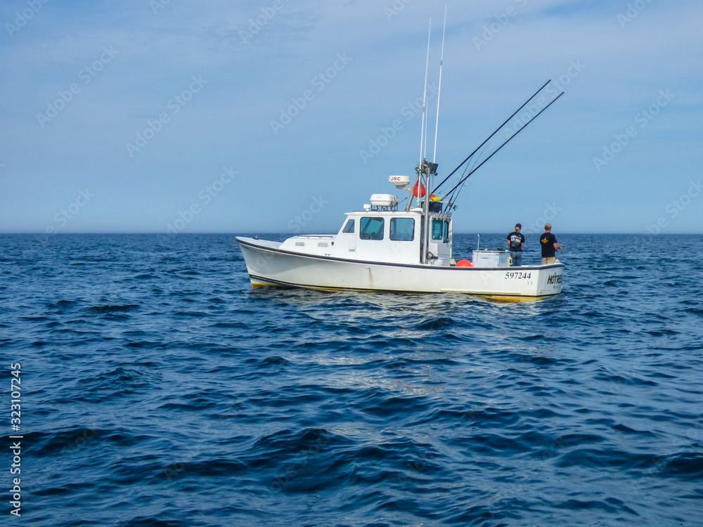 Couple fishing off a boat on the blue Atlantic Ocean off Cape Cod