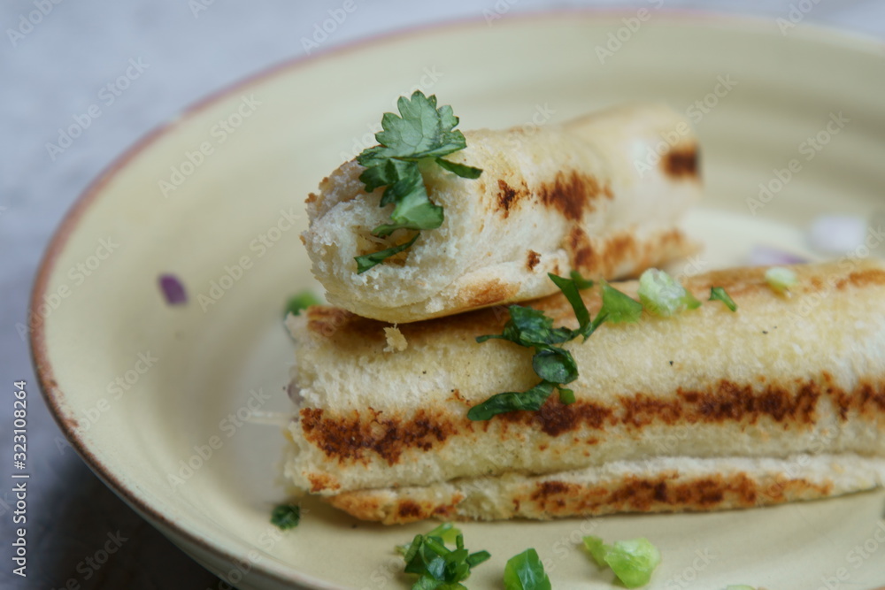 A stack of toasted bread filled with a mixture of cheese, onion, peppers and cilantro on a plate. A stack of toasted bread filled with a mixture of cheese, onion, peppers and cilantro on a plate.