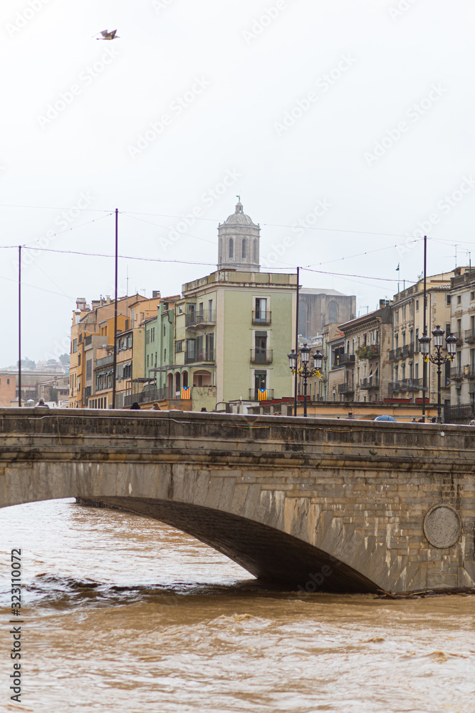 Brown growing river Onyar on hard rainstorms in Girona, Catalonia