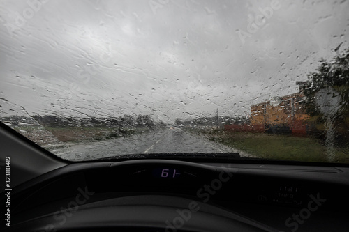 Rain falling on a windscreen while driving on a highway road without visibility
