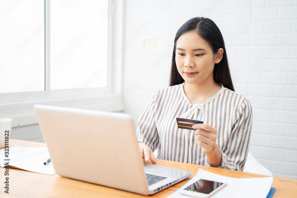 Technology, Online shopping, Digital banking, home lifestyle concept, a beautiful Smiling Asian woman with a laptop computer and credit card at home for business payment, career, e-commerce trading Technology, Online shopping, Digital banking, home lifestyle concept, a beautiful Smiling Asian woman with a laptop computer and credit card at home for business payment, career, e-commerce trading