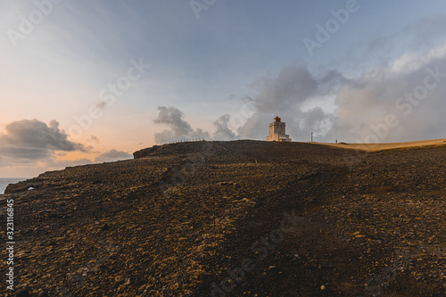 Lighthouse on the top of the hill during sunset. Beautiful landscape with lighthouse in Iceland.