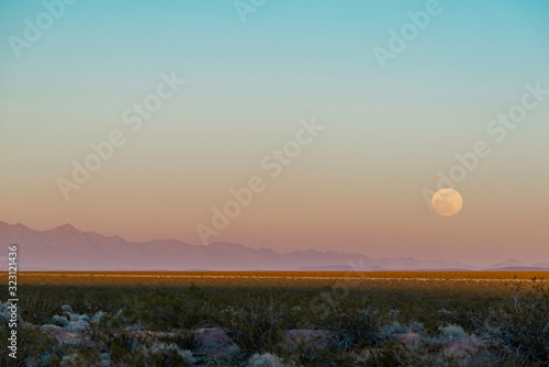 USA  Nevada  Clark County  Eldorado Valley  Boulder City. A full snow super moon hanging low in the sky behind pollution in this otherworldly night scene.