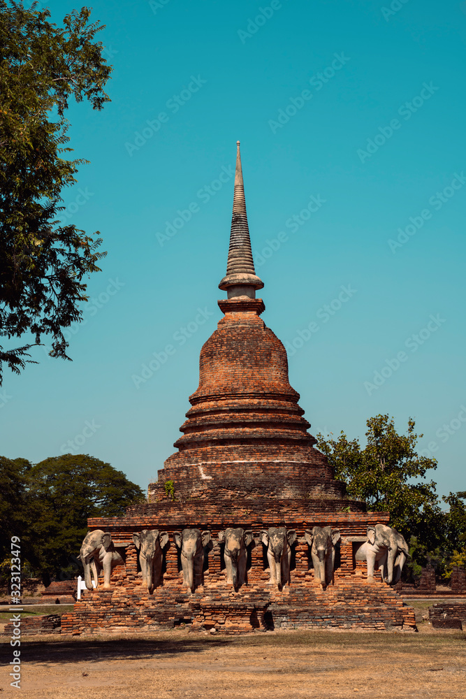 Wat Chang Lom in the historical temples in Sukhothai, the ancient city with buddhist heritage in the north east in Thailand. Travel to Asia and holidays concept. Elephant sculptures around the stupa.
