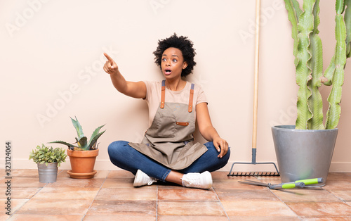 Gardener woman sitting on the floor pointing away