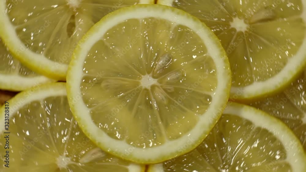 Close-up view from the top of sliced lemon slices. Sliced lemons spin in a circle. Many fresh lemons at table. Close-up view from the top of sliced lemon slices. Sliced lemons spin in a circle. Many fresh lemons at table.