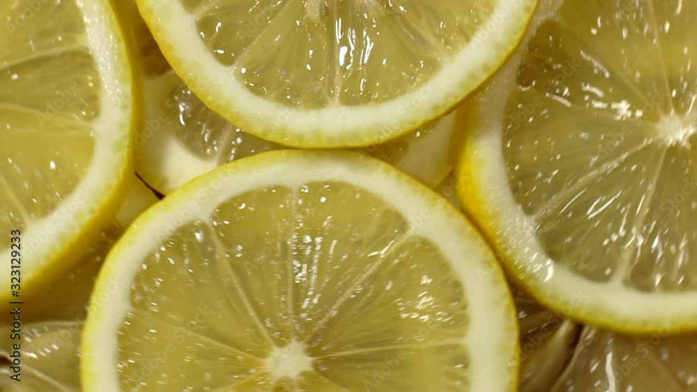 Close-up view from the top of sliced lemon slices. Sliced lemons spin in a circle. Many fresh lemons at table. Close-up view from the top of sliced lemon slices. Sliced lemons spin in a circle. Many fresh lemons at table.