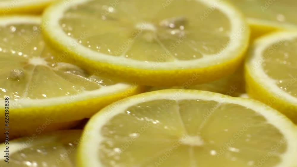 Close-up view from the top of sliced lemon slices. Sliced lemons spin in a circle. Many fresh lemons at table. Close-up view from the top of sliced lemon slices. Sliced lemons spin in a circle. Many fresh lemons at table.