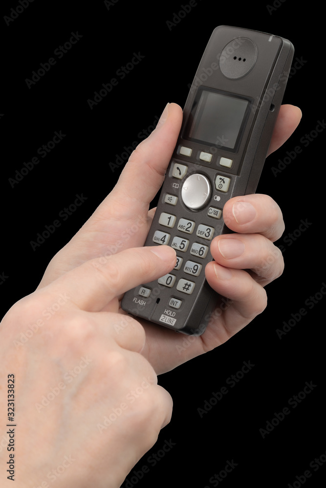 Female hand holds a phone, isolated on black background Female hand holds a phone, isolated on black background