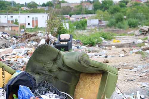 Damaged green armchair on debrise photo