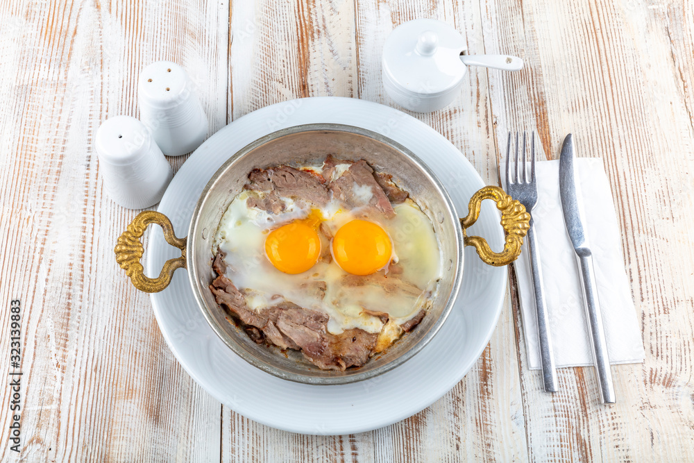 Turkish Doner Fried Eggs in copper pan. Stock Photo Adobe Stock